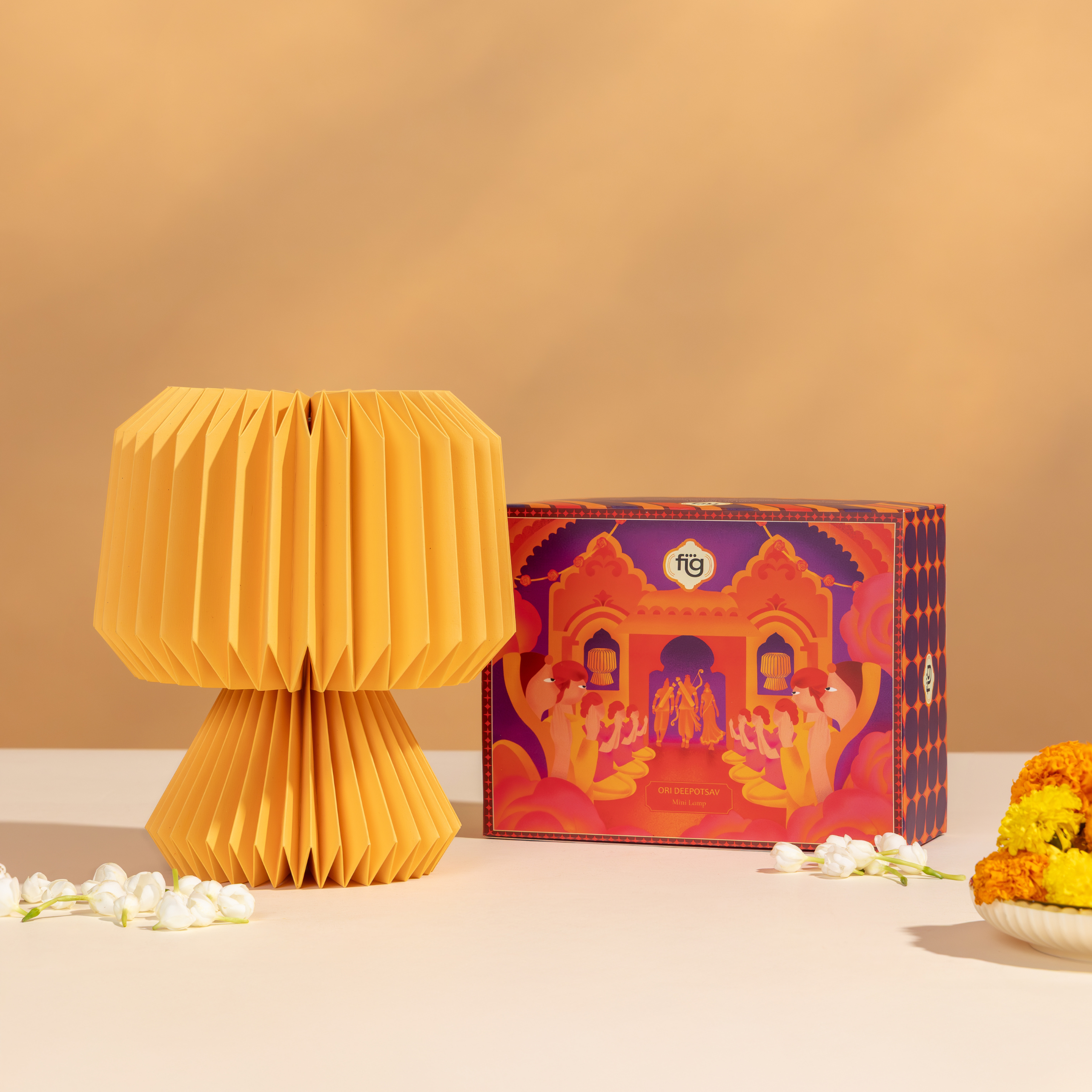 Yellow folded ori lamp and decorated box on a beige background