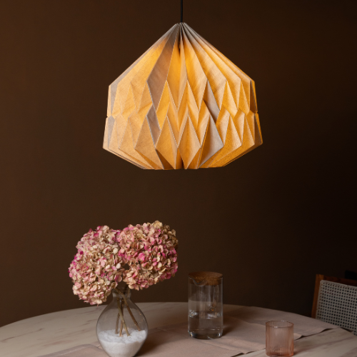 Big Pleat linen pendant light fixture hanging above a table with decorative elements.
