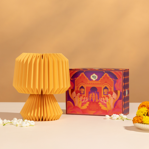 Yellow folded ori lamp and decorated box on a beige background