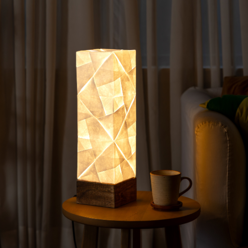 Solobe A table lamp with geometric pattern on a small round table in a dimly lit room.