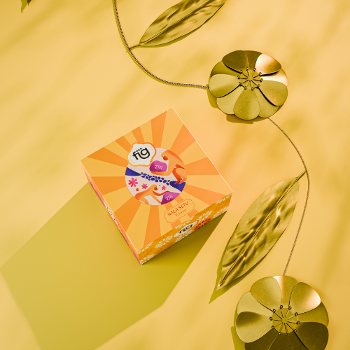 Colorful brass toran product packaging on a yellow background with decorative leaves.